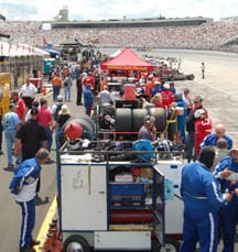 The WMT cars roll off pit road in front of a large crowd.