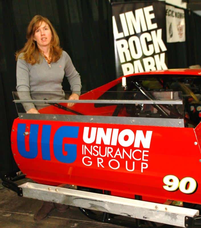 Renee poses with her UNION Insurance Group sponsored car on display in the Lime Rock Park booth.